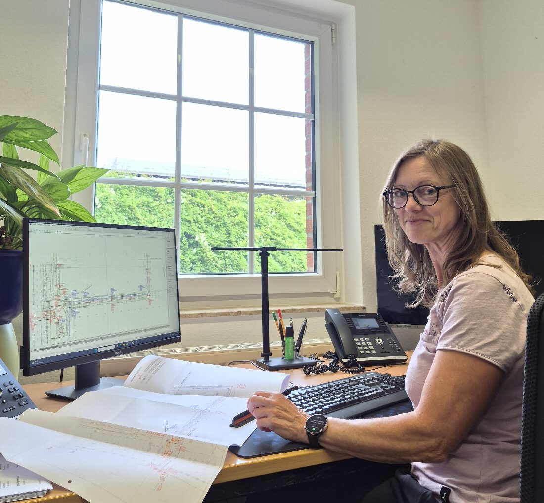 Dipl.-Ing. Mara Hagemeister an ihrem Arbeitsplatz mit Plänen und Planungssoftware am Bildschirm.