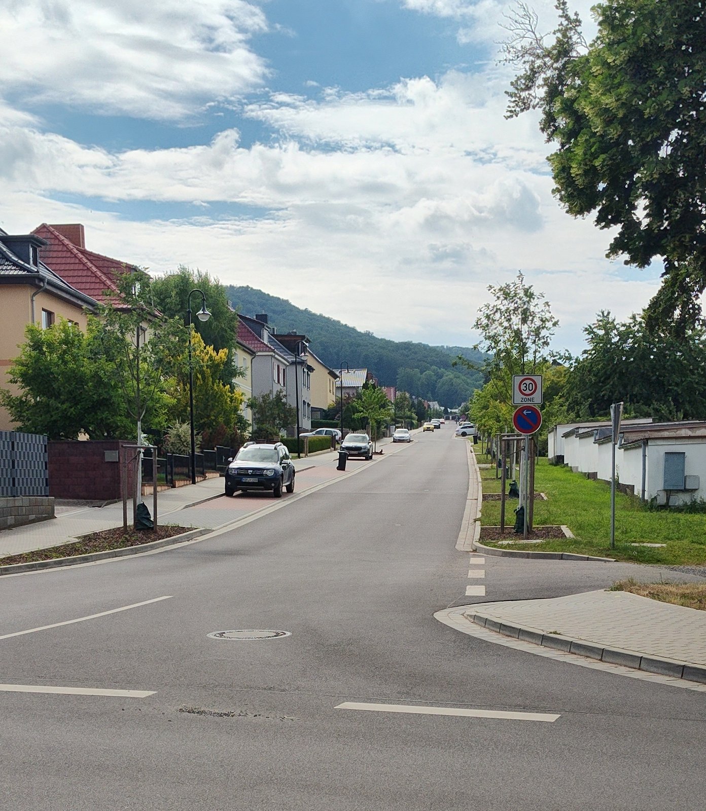 Erneuerte Johannes-Kleinspehn-Straße in Bleicherode: neue Fahrbahn mit Parkstreifen, junge Straßenbäume und Tempo-30-Zone.