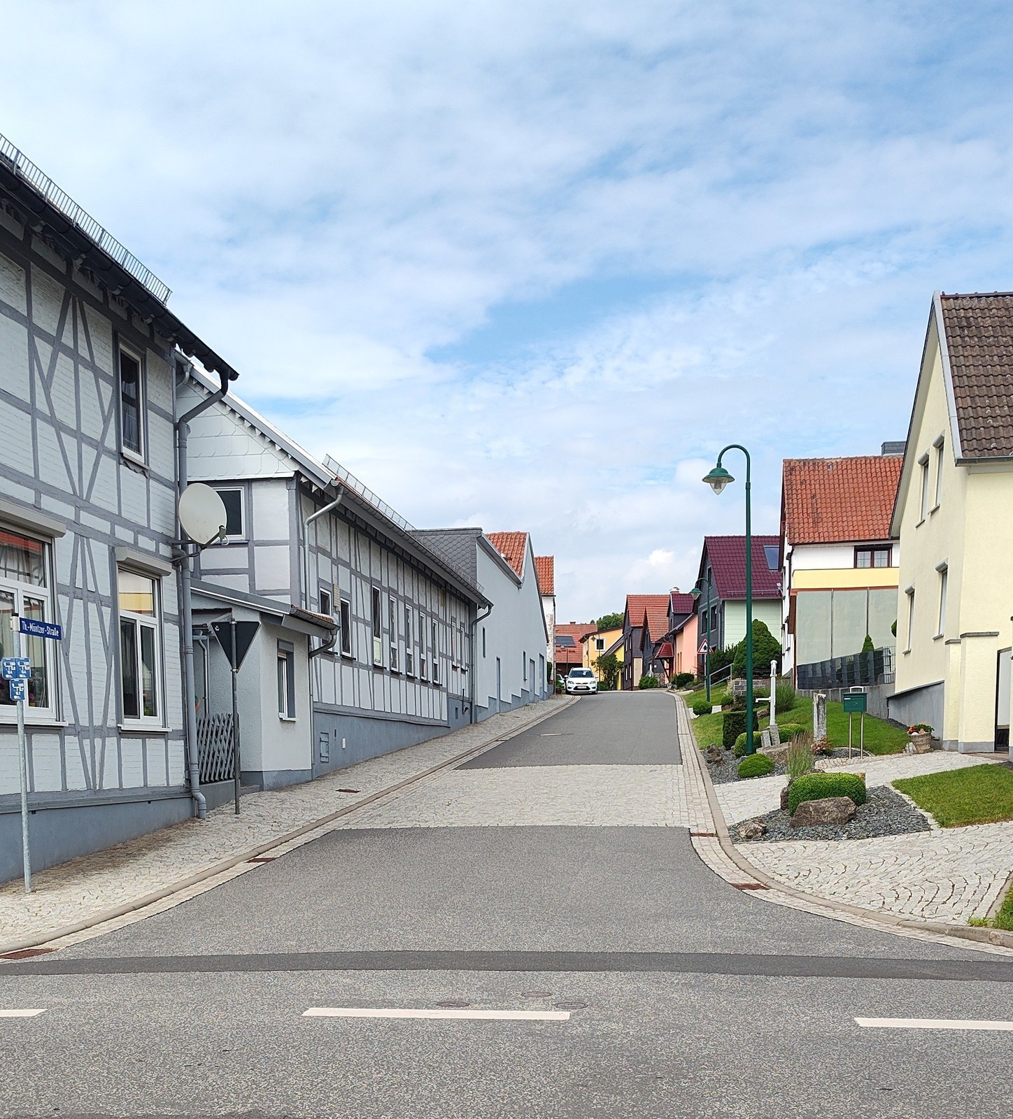 Ausgebaute Thomas-Müntzer-Straße in Kehmstedt mit Fachwerkhäusern und neuer Fahrbahn.