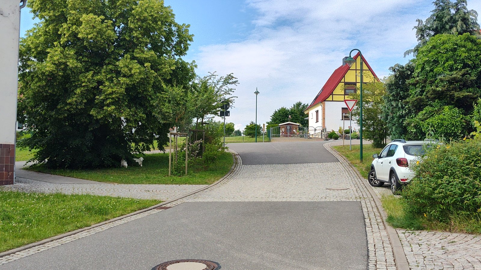Ortsstraße in Kehmstedt nach dem Ausbau, mit gepflasterten Nebenanlagen und Einmündung.